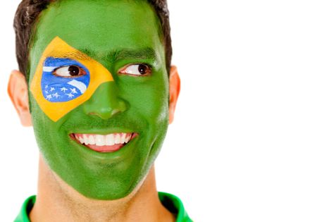 Happy Brazilian man with flag painted on his face - isolated
