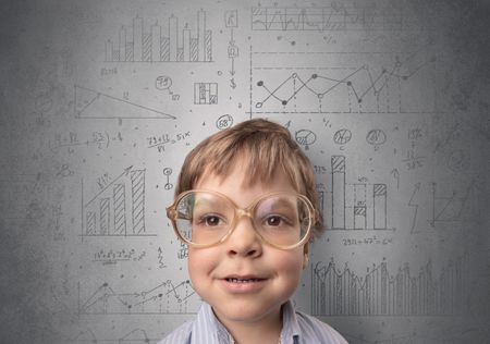 Little boy in front of a grey wall with graphs and statistics around