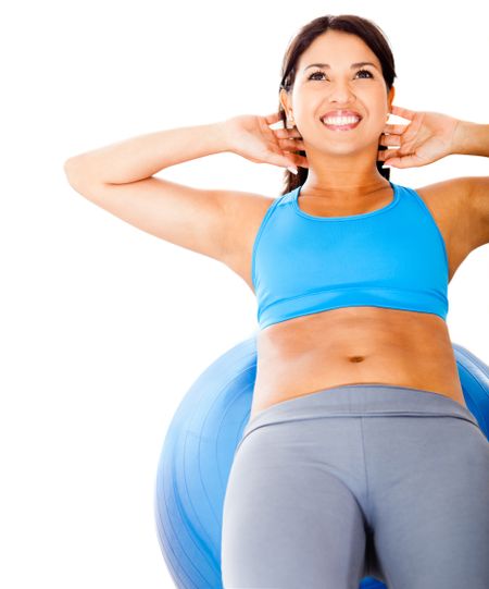 Woman exercising her abs on a Pilates ball - isolated over white