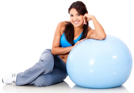Beautiful sporty woman with a Swiss ball - isolated over white