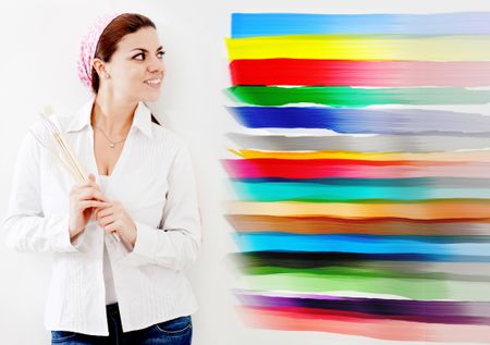 Woman painting a wall of the house and choosing from different colors