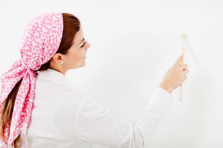 Woman painting and holding a paint brush - isolated over white