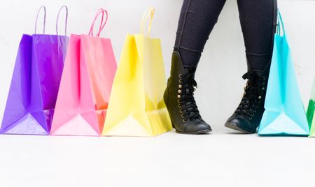 Woman with shopping bags buying shoes - isolated