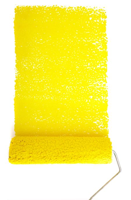 rolling pin with yellow paint on a white wall