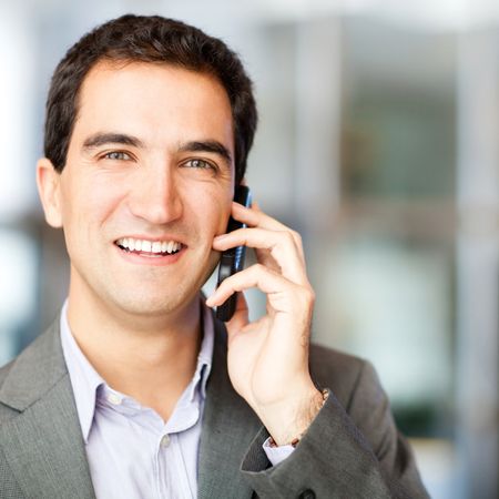 Businessman talking on his cell phone at the office