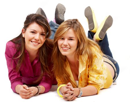 teenage girls smiling while lying on the floor isolated over a white background