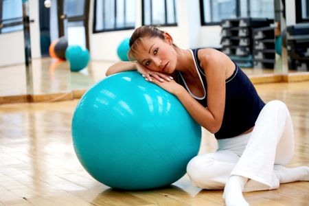 girl doing pilates in a gym with a ball