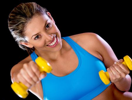 Gym woman lifting weights - isolated over a black background
