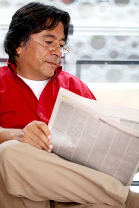 man reading the newspaper at his home