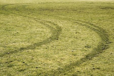 Tire tracks winding across soggy soccer field in winter