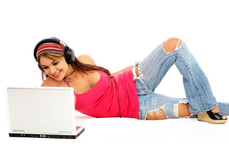 Casual student listening to music on the computer while studying isolated over a white background