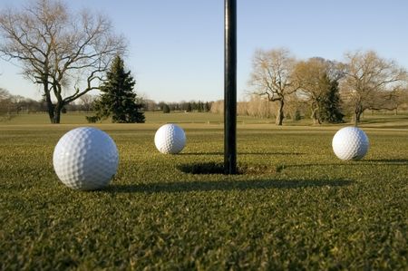 Three golf balls near the pin