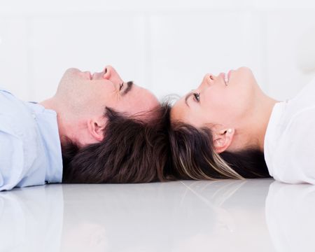 Couple lying on the floor looking up and smiling
