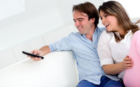 Couple watching television and holding a remote control