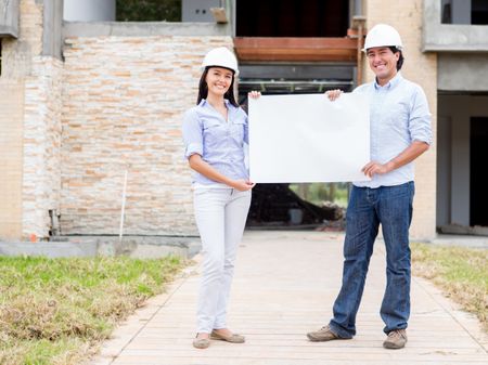 Architects holding banner in a construction site