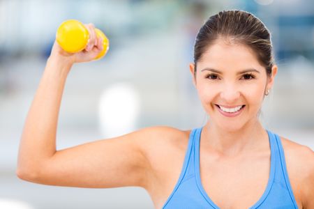 Strong woman at the gym lifting free-weights
