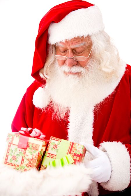 Santa looking at Christmas gifts - isolated over a white background
