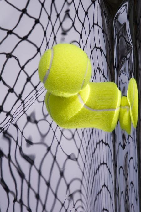 Tennis net and yellow ball with warped reflections