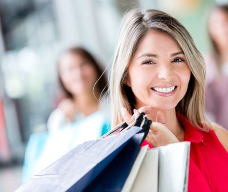 Beautiful shopping girl holding bags and smiling