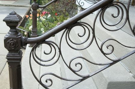 Iron railing with filigree in front of urban walkup