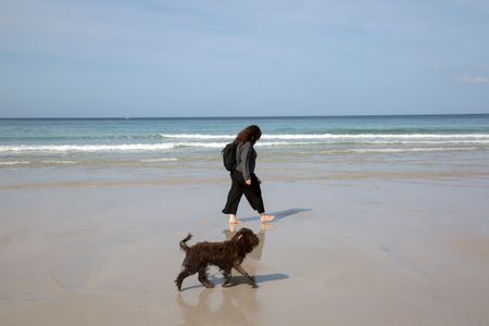 Woman and Dog on Beach in Galicia; Spain