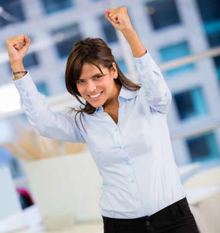 Businesswoman celebrating her triumph with arms up