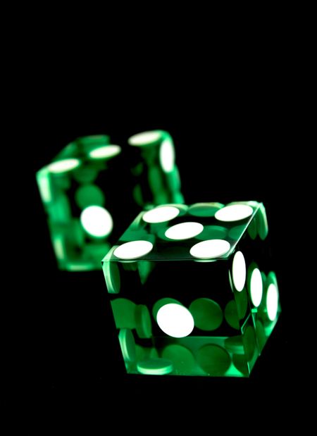 green dices - shot in studio over a black light absorbent backdrop