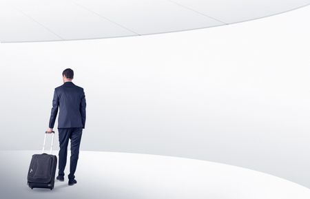 Businessman with back walking in a white waiting room with empty walls around