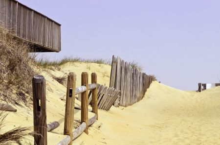 Way to the beach: Public access by wooden fences and corner of house deck overlooking the ocean