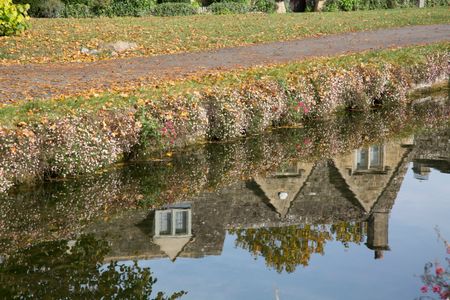 Reflection of House in River; Cotswold Village; Cheltenham; England; UK