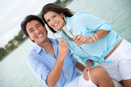 Couple drinking champagne on a yacht looking happy