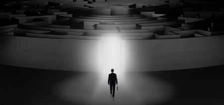 Businessman getting ready to enter a concentric labyrinth with lighted entrance concept