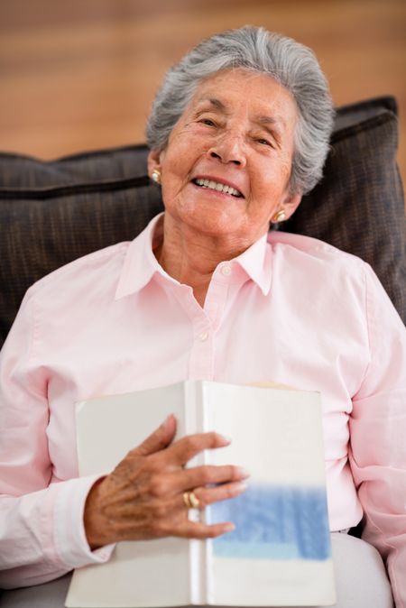 Lovely senior woman reading a book at home