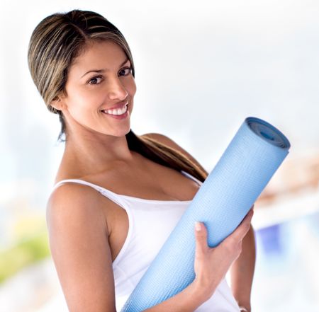 Beautiful portrait of a woman holding yoga mat