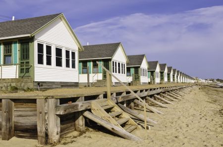 Conformity at the beach: Long row of identical white beach cottages in Cape Cod, Massachusetts