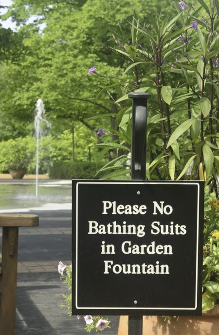 Sign to discourage playing in fountain of formal garden