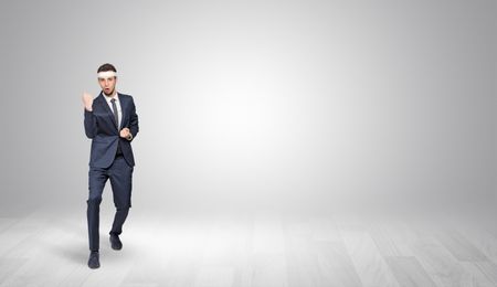 Young businessman in suit fighting in an empty space