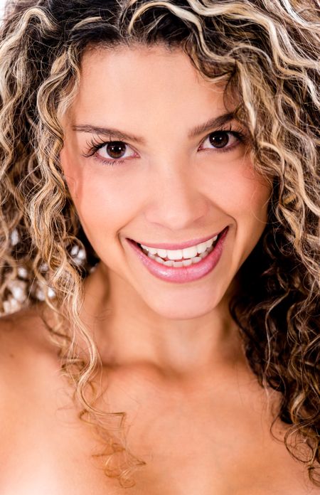Female beauty portrait of a woman smiling with curly hair