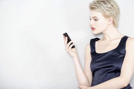 Professional business woman on her mobile phone; wearing a smart dress
