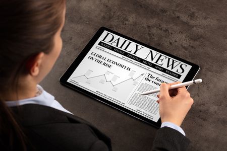 Business woman reading news on tablet
