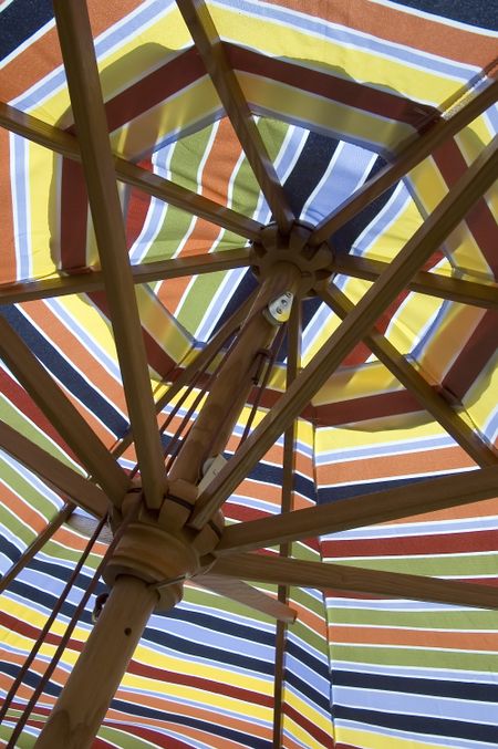 Underside of colorful umbrella with collapsible wooden frame