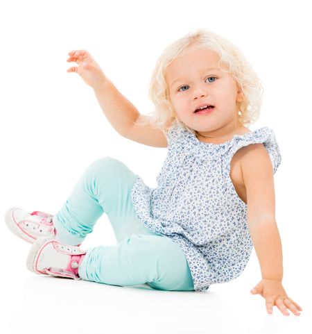 Cute little girl sitting on the floor - isolated over white background