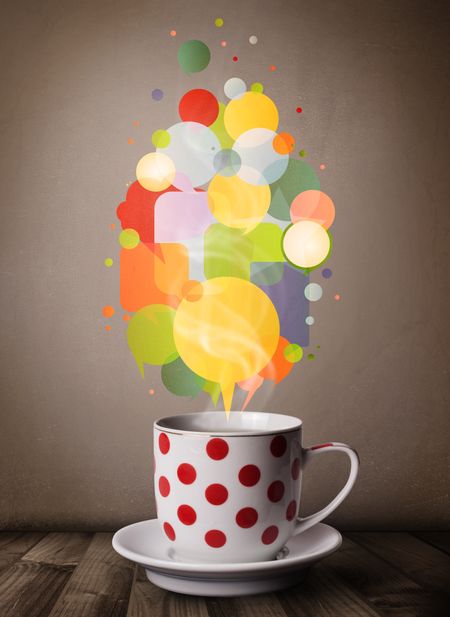 Tea cup with colorful speech bubbles, close up