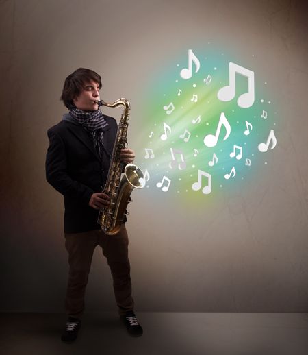 Attractive young musician playing on saxophone while musical notes exploding