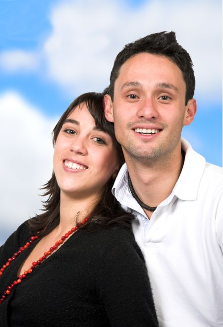 happy casual couple with the sky in the background, clipping path for you to isolate the photo is included with high detail in the hair