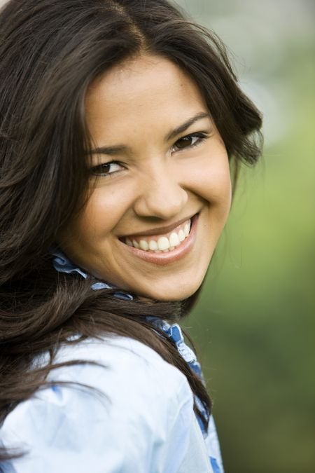 Beautiful girl portrait looking happy - smiling outdoors