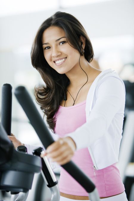 Girl exercising at the gym on stepper machine - looking happy