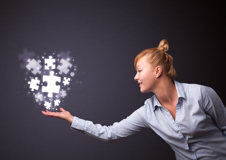 Businesswoman holding shining puzzle pieces in her hand