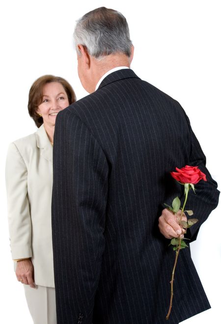 business partners - man is hiding a flower from her ready to give her the surprise - over white