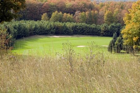 Dogleg with bunkers on golf course in northern woods in autumn